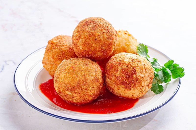Arancini appetizer with tomato sauce, on a white plate, homemade, no people