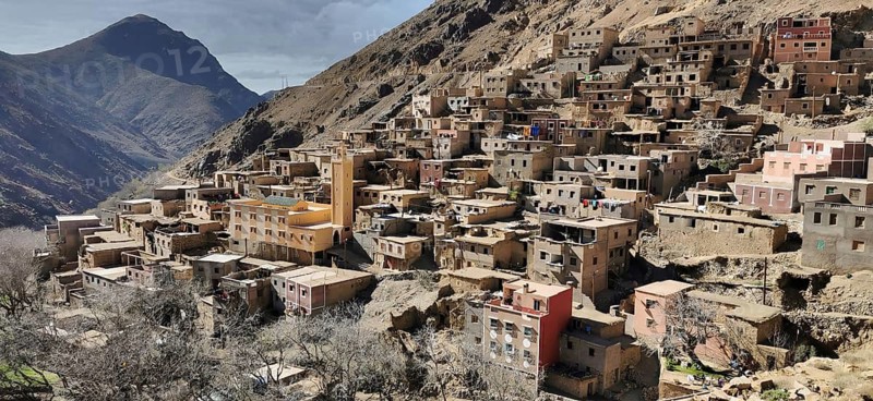A densely built village on a mountain flank with terraced areas, Toubkal region, hiking in the High Atlas Mountains, Morocco