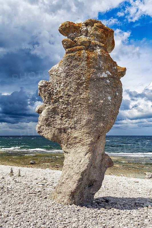 Raukar, bizarre monumental limestone column on a pebble beach, dramatic rain clouds, Langhammars Nature Reserve, Fårö Island, Gotland, Baltic Sea, Sweden
