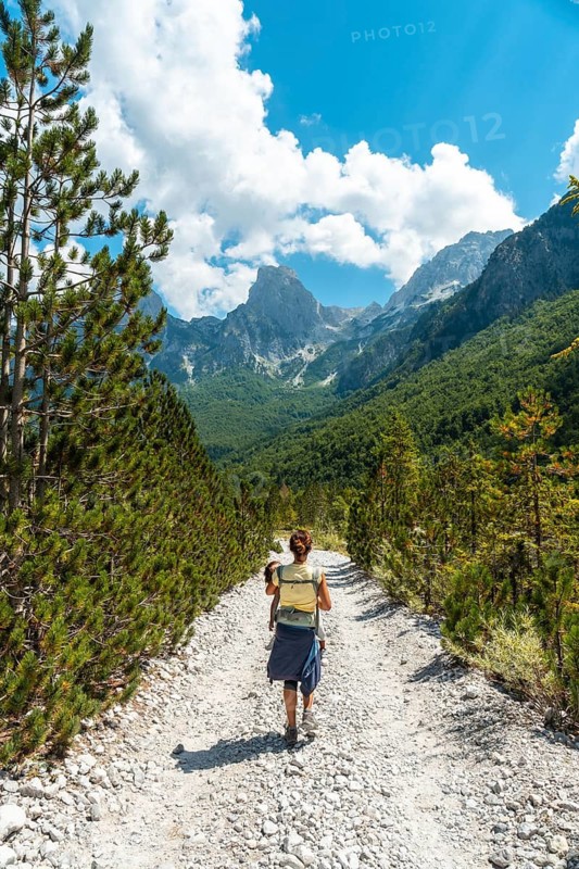 Woman hikers walking in Valbona valley next to trees, Theth national park, Albanian Alps, Albania