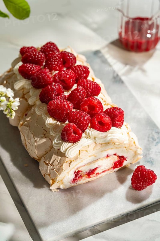 Delight in a luscious raspberry meringue roulade, filled with whipped cream and topped with fresh raspberries. This delectable dessert is perfect for any special occasion or afternoon treat