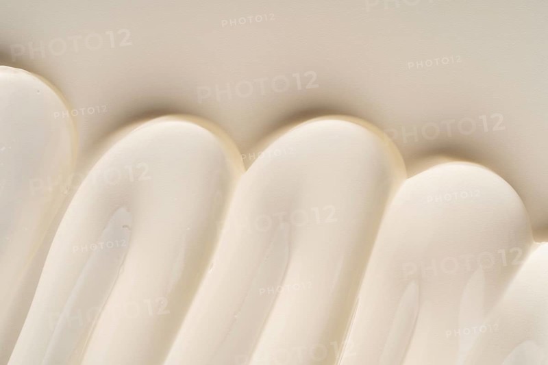 A close-up of a creamy cosmetic gel texture in soft, curved waves creates a soothing and elegant background. The minimalist aesthetic highlights smooth, seamless form and fluidity