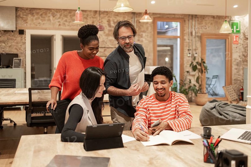 A diverse team collaborates energetically in a modern coworking space The warm ambiance and creative environment foster teamwork and innovation, perfect for dynamic projects