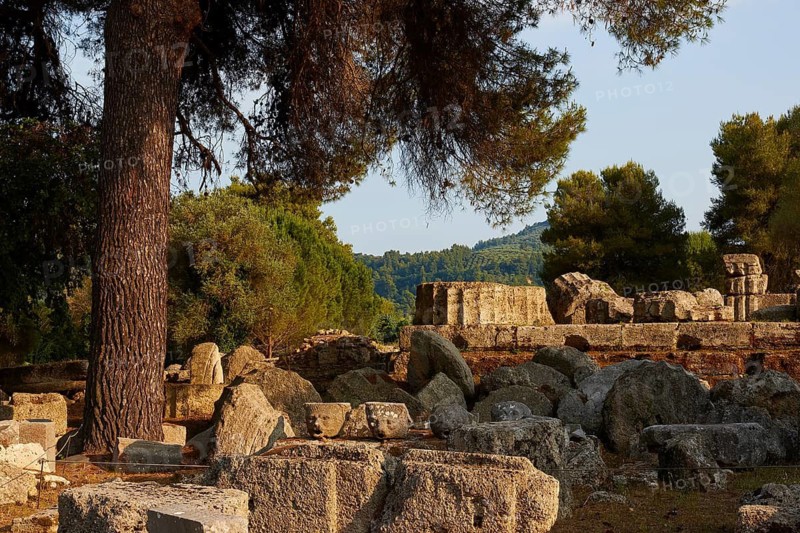 Ancient stones and fragments under trees in a ruined site, Archaeological Site, Ancient Olympia, Olympia, Peloponnese, Greece