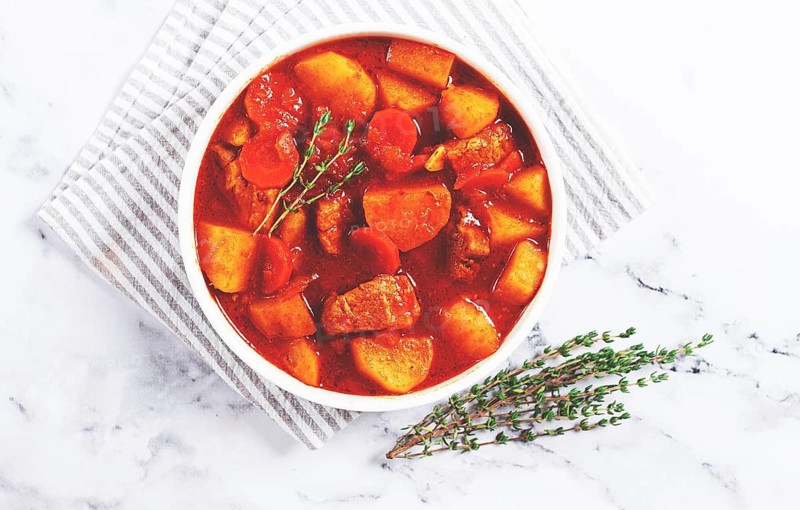 Meat goulash with potatoes and carrots, sweet peppers, in a saucepan, top view, traditional Hungarian soup, homemade, no people