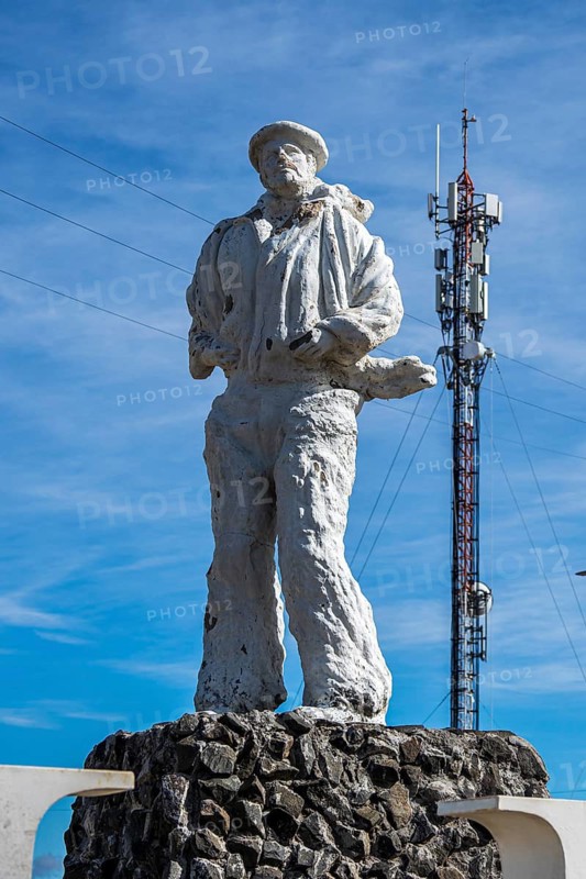 Statue of a pioneer, early settler monument, radio mast, contrast old-new, Balmaceda, Chile