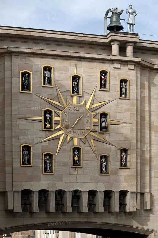 Large golden wall clock with twelve figures at the back of the Dynasty Palace, Brussels, Belgium