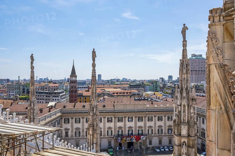 Sculptures of saints gaze down on the city from Milan Cathedral on a sunny day, Milan, Italy