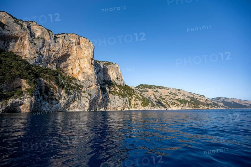 Picturesque rocky coast, cliffs in morning light, blue sea, Golfo di Orosei, Baunei, Sardinia, Italy