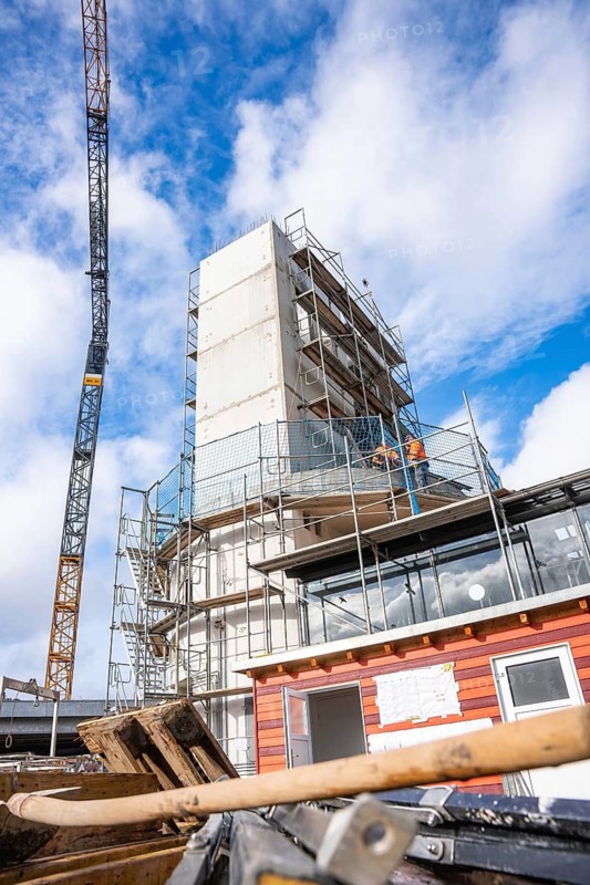 Construction site with large crane and scaffolding under a clear sky, extension of the Calw railway station for the new track of the Hermann Hessebahn, Calw, Black Forest, Germany