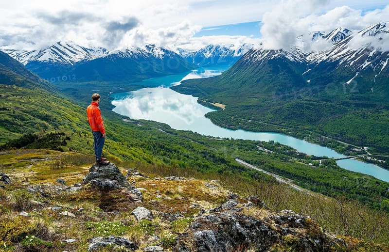 Climber enjoying the view, Slaughter Ridge Trail, view of snowy mountains and turquoise blue Kenai Lake, Cooper Landing, Kenai Peninsula, Alaska, USA