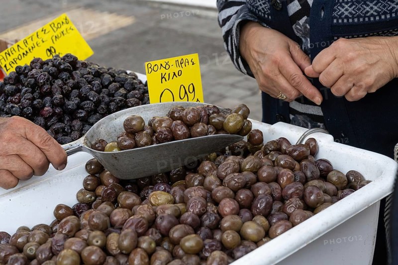 Athens, Greece. April 24th 2025. Buying fresh olives from a market stall trader at an Athens street market, Greece