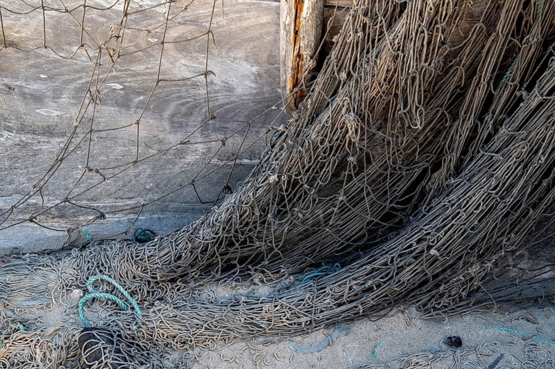 Close-up view of old fishing net hanging on boat, Oman