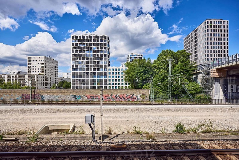 Car bridge and pedestrian bridge, general architecture, skyscrapers, modern building, commercial building, Hotel Holiday Inn Express, Group Center Flix SE, Flixtrain, railway track, power poles, trees, elevated perspective, blue sky, cumulus clouds, Friedenheimer Bridge, Munich, state capital, district-free city, Bavaria, Germany