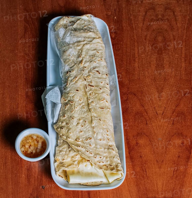 Top view of Nicaraguan Quesillo on a plate served on wooden table. Delicious traditional Nicaraguan quesillo served on wooden table, View of a Nicaraguan quesillo served on table
