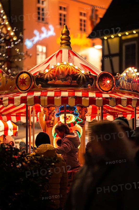 Lively Christmas market with a colourfully illuminated carousel in a festive atmosphere, Christmas market Calw, Black Forest, Germany