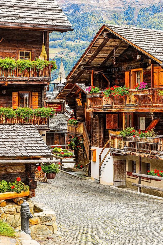 Old wooden houses decorated with flowers in the historic village centre, Grimentz, Val d'Anniviers, Valais Alps, Canton Valais, Switzerland