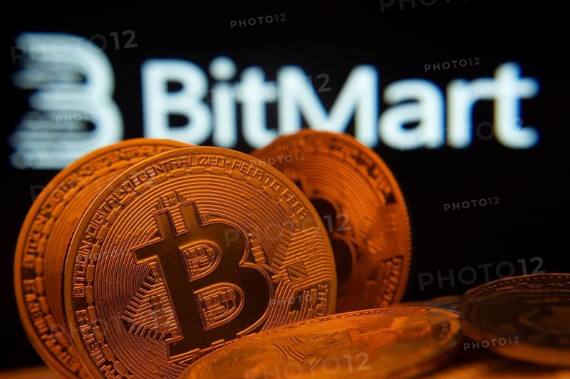 Dhaka, Bangladesh- 03 Sep 2025: Close-up of Bitcoin coins with the Bitmart logo visible on a screen in the background