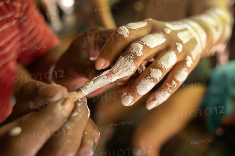 Tourists experience traditional body painting on Waigeo Island, Raja Ampat. This cultural art form is part of a rich heritage in Papua, Indonesia, offering a unique travel experience
