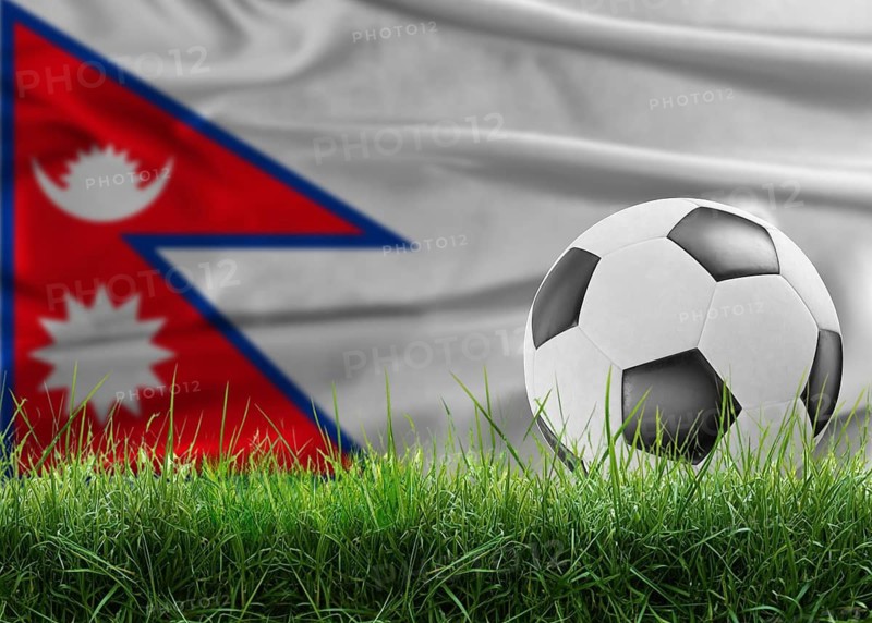 Soccer ball on pitch against Nepalese flag background. Soccer ball on the grass with Nepal flag in the background