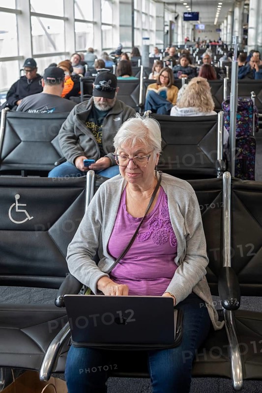 Detroit, Michigan - Susan Newell, 76, works on her laptop computer while waiting for a flight at Detroit Metro Airport