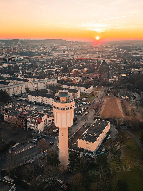 Urban landscape with water tower in the foreground and sunset in the background, Sindelfingen, Germany