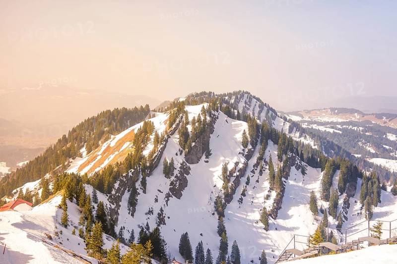Impressive mountain ridge with snow and trees, lying under a clear sky, Hochgrat Mountains, Allgäu Alps, Oberreute, Germany