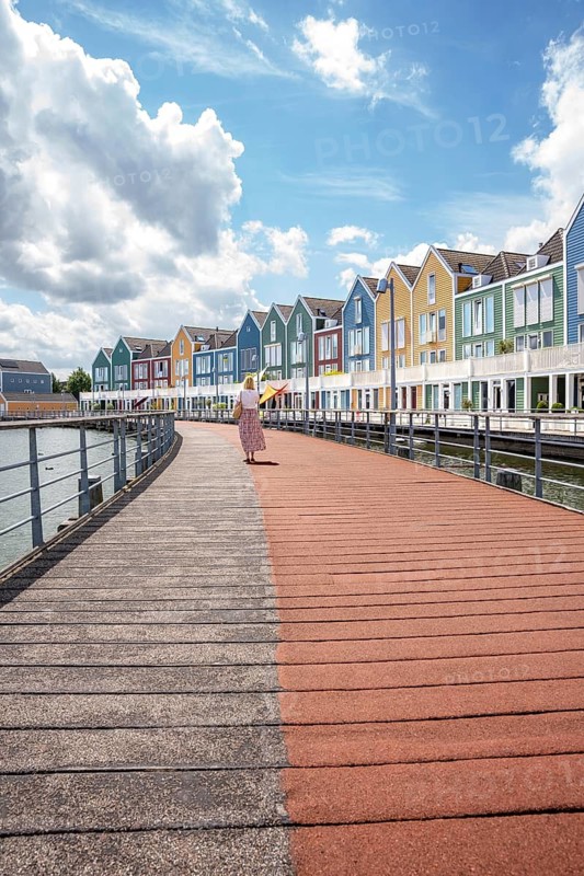 Woman in front of colourful houses by the water, Houten Netherlands