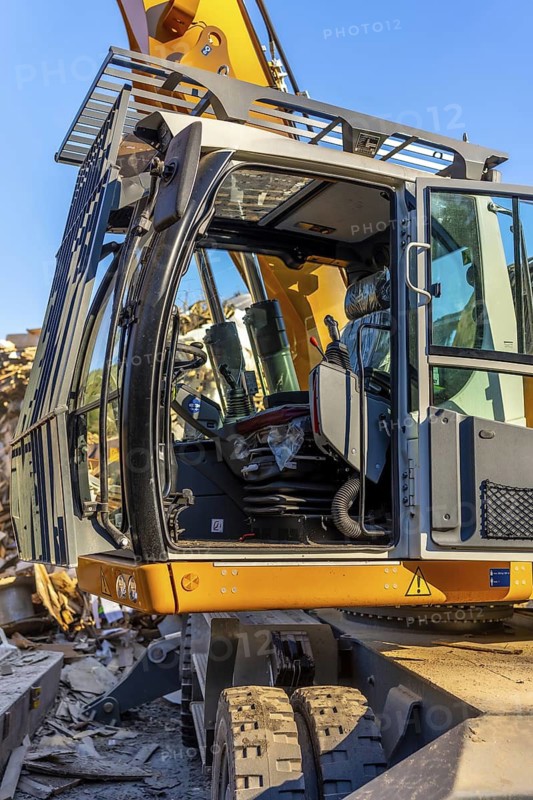Vertical photo with no people and close-up of an excavator outside a recycling plant