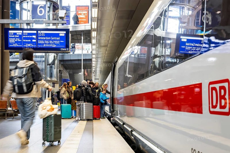 Berlin Central Station. ICE on the platform with travelers. ICE144 to Amsterdam CS. Berlin, Germany