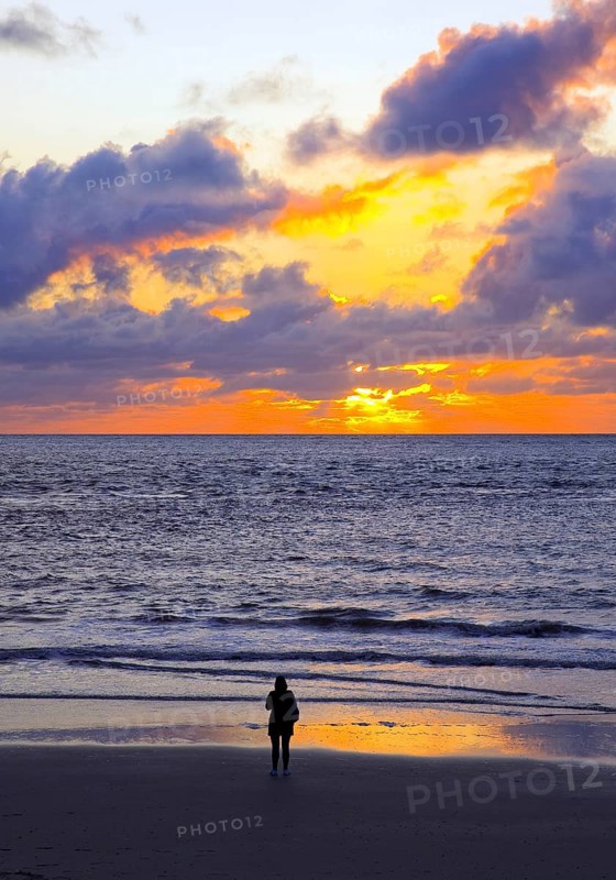 Mudflat landscape with setting sun and a person at the sea, Norderney Island, North Sea, East Frisia, Lower Saxony, Germany