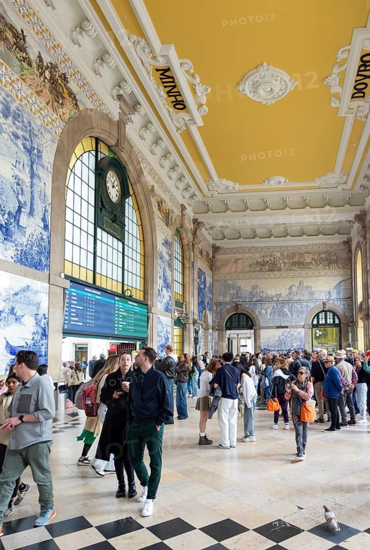 Tour groups viewing historic azulejos tiles, Sao Bento railway station building, city of Porto, Portugal