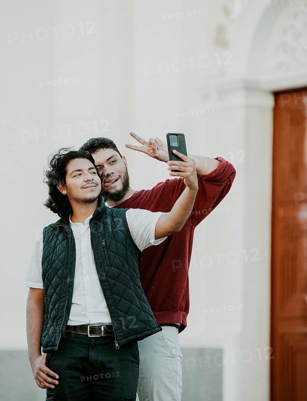 Cheeful friends taking funny selfie on the street. Portrait of funny friends taking a selfie on the street