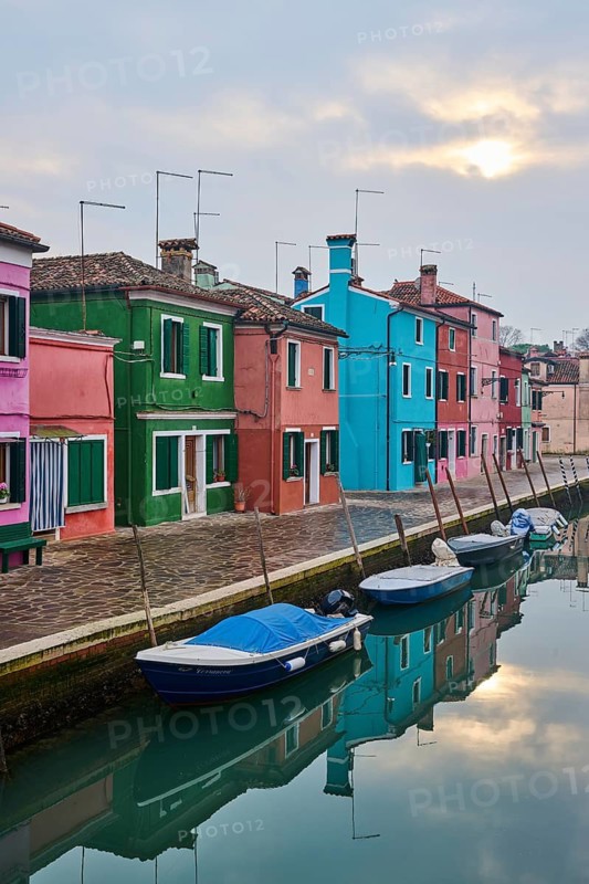 Colorful houses beside the waterway in between 'Riva dei Santi' and 'Fondamenta di Terranova' with boats lying in the water on the island of Burano, Italy