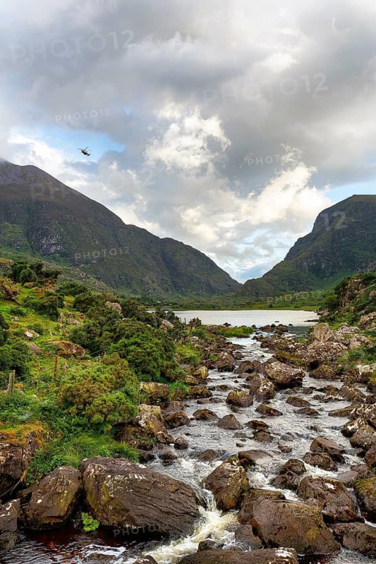 Stream, lakeside, rescue helicopter flying at dusk, Gap of Dunloe mountain pass, Killarney, Ring of Kerry scenic road, Iveragh Peninsula, County Kerry, Ireland