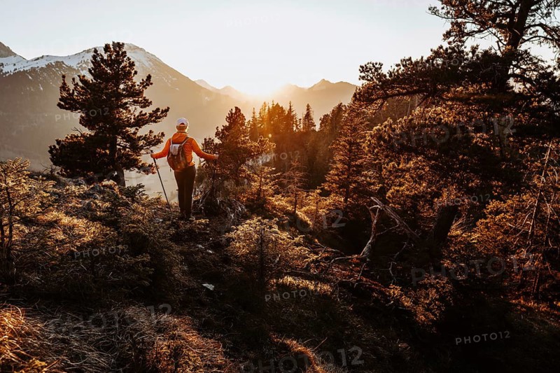 Hiker in the Allgäu at sunset in spring on the Zirmgrat near Pronten in the Allgäu