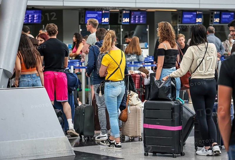 Düsseldorf, North Rhine-Westphalia, Germany, Düsseldorf Airport, Holidaymakers stand with suitcases at the check-in counter on the day of the warning strike by Lufthansa ground staff