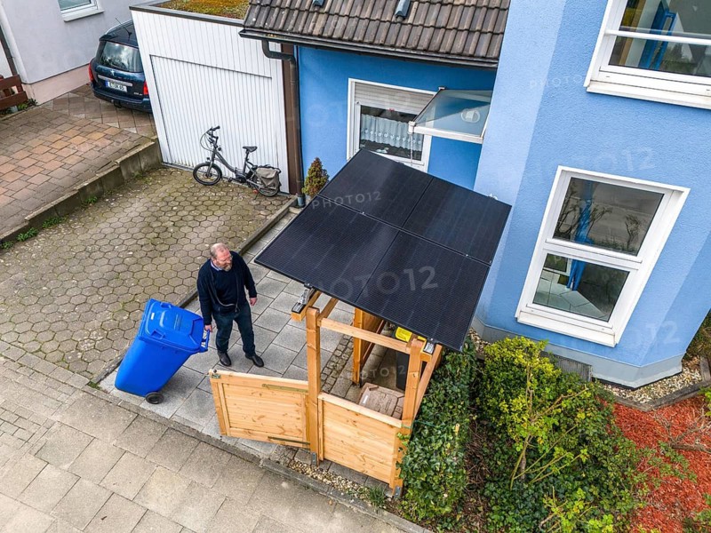 Detached house with various solar modules, in addition to solar panels on the roof of the house, plug-in solar modules are mounted on a dustbin box as a roof, Essen, North Rhine-Westphalia, Germany