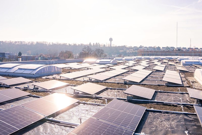 Large-scale view of a roof with numerous solar panels and an urban background, PV installation at OBI Baumarkt, Mühlacker, Enzkreis, Germany