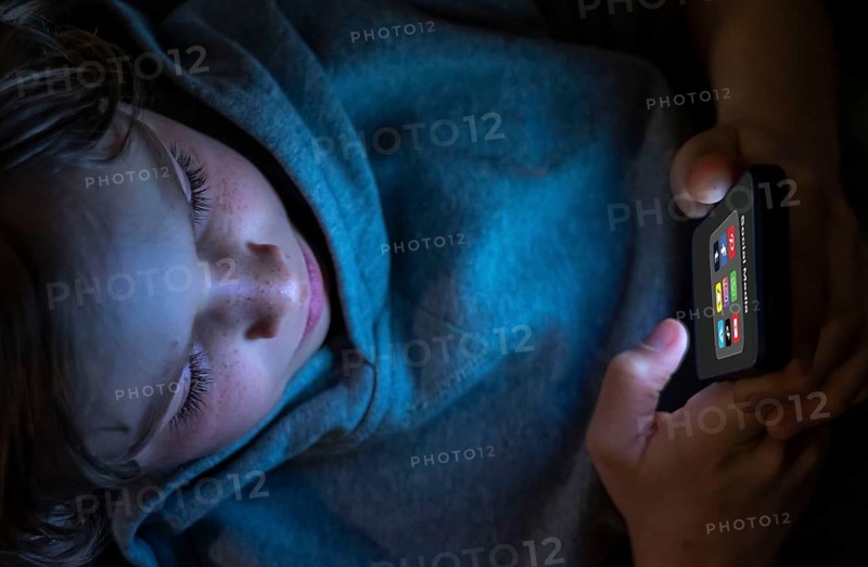 Symbolic image of social media use by young people, children, boy, 12 years old, folder with various social media platforms on the mobile phone