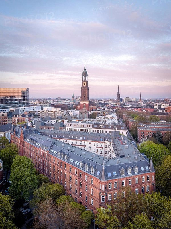 Aerial view over Hamburg at dusk with the main church St Michaelis (Michel), historic brick buildings and green parks, St Pauli, Hamburg, Germany