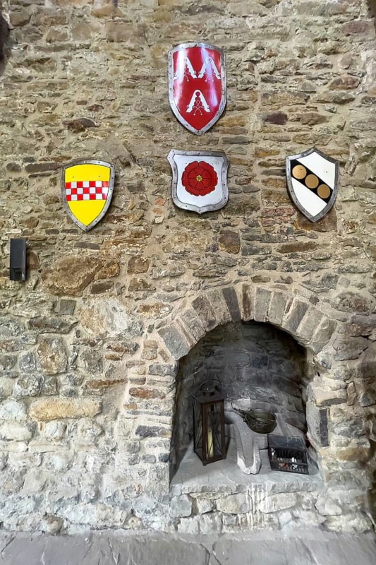 Old historic open fireplace in the restored historic castle tower of Burg Altendorf in the Burgaltendorf district of Essen, with four coats of arms on the wall above, Essen, North Rhine-Westphalia, Germany