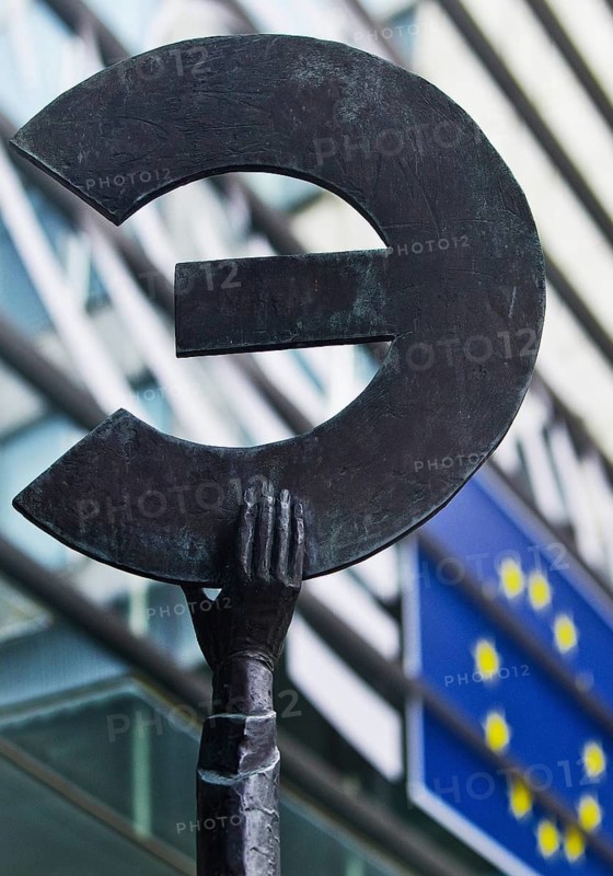 The bronze statue entitled Europe by May Claerhout holds up the euro symbol in front of the EU flag, European Parliament, Brussels