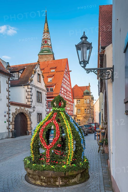 Alley with Easter fountain, half-timbered houses and cobblestones in the old town centre in the evening, behind the Liebfrauenmünster, Wolframs-Eschenbach, Middle Franconia, Bavaria, Germany