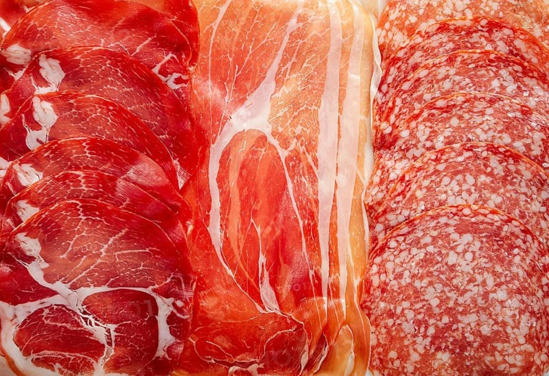 Assortment, sliced meat appetizer, prosciutto, salami and ham, with olives, breakfast, top view, close-up, no people