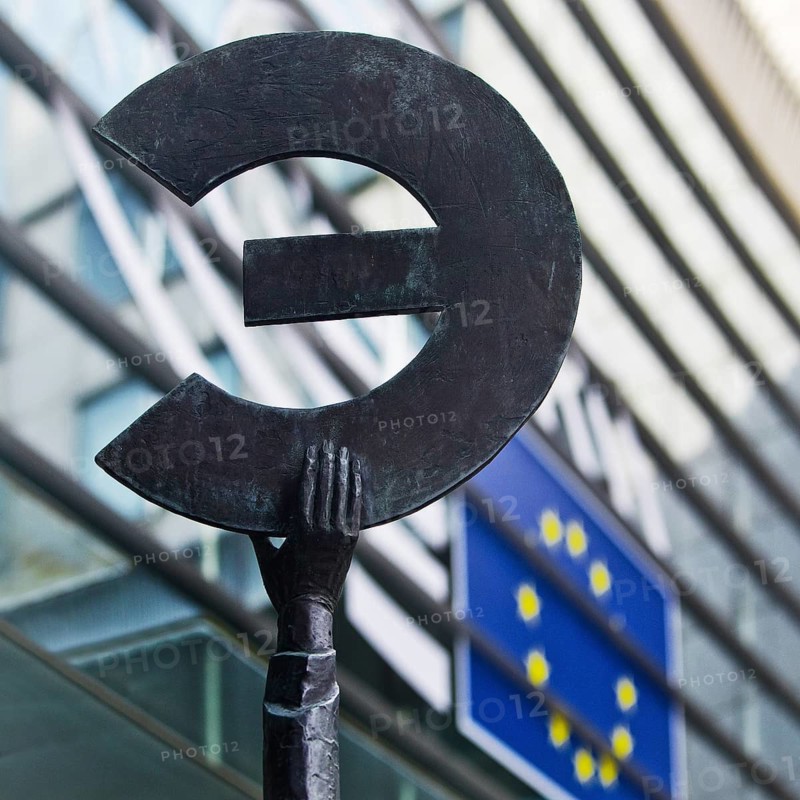 The bronze statue entitled Europe by May Claerhout holds up the euro symbol in front of the EU flag, European Parliament, Brussels
