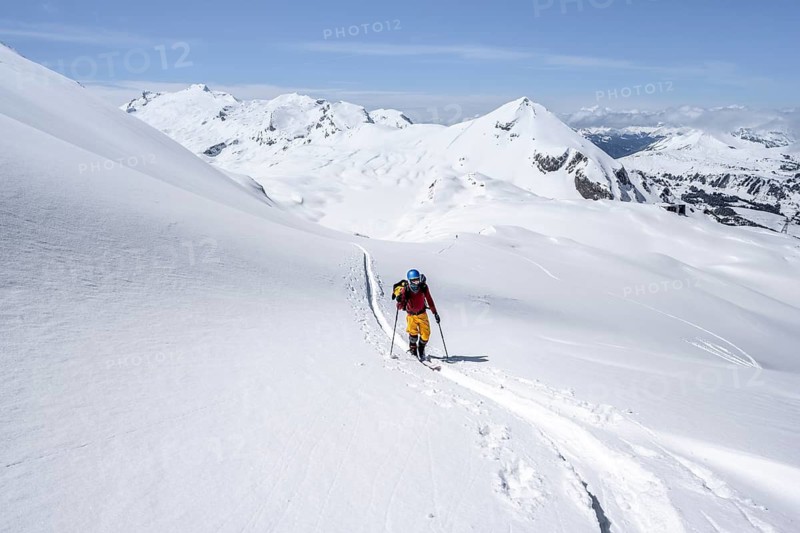 Ski tourer in mountain landscape with snow, behind summit Mittaghorn and Wildhorn, ascent to Wildstrubelhütte, Bernese Alps, Switzerland
