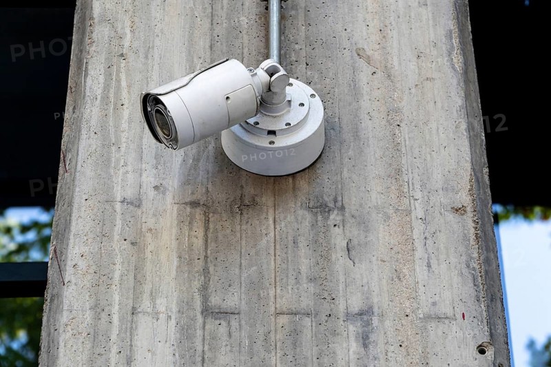 Security surveillance camera attached to a concrete pole, monitoring urban area, enhancing safety and surveillance capabilities