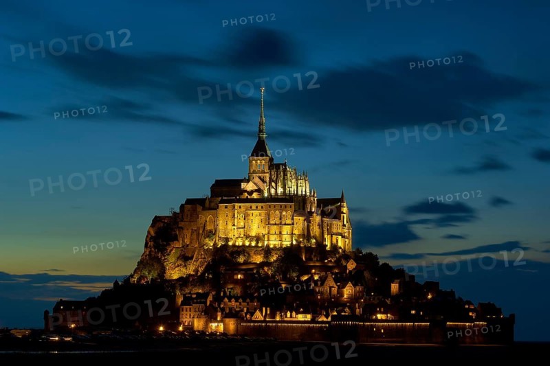 Illuminated Mont Saint-Michel at night against a blue-black sky, Gothic architecture on a rocky island in the sea, Le Mont-Saint-Michel, Brittany, Normandy, France