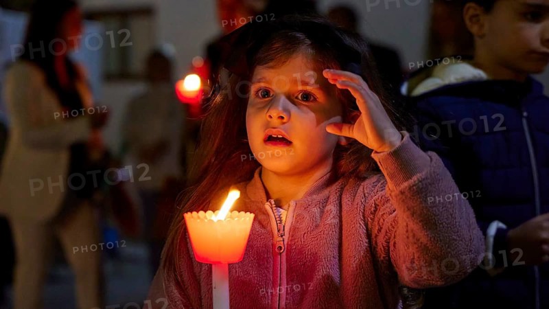 A little girl holds a lighted candle in her hand, her face filled with astonishment and illuminated by the warm glow, Holy Light, Easter Fire Psinthos, Holy Saturday, Easter, Psinthos, Rhodes, Dodecanese, Greek Islands, Greece